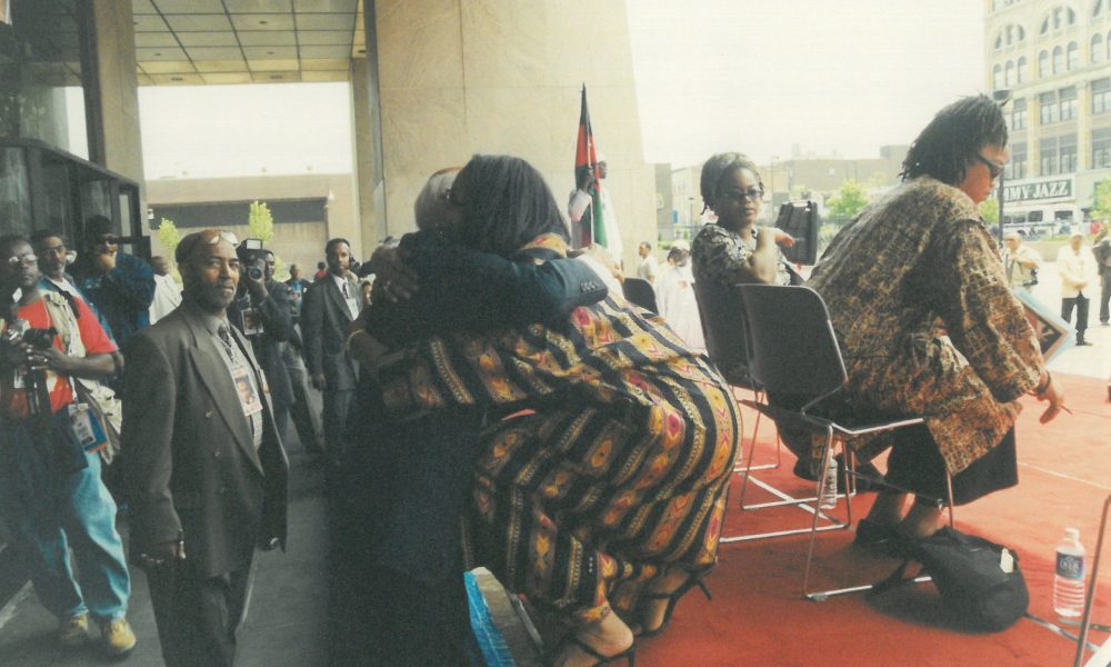 Percy Sutton hugging Malcolm X's daughter